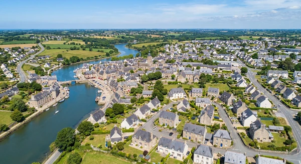 Vue aérienne ou paysagère de la ville d'Auray montrant son tissu urbain, ses quartiers résidentiels et leurs alentours, photographiée en journée avec une bonne luminosité naturelle. L'image doit transmettre l'accessibilité et la proximité de l'entreprise pour les habitants de cette zone. Photographie réaliste de haute qualité professionnelle sans texte, logo ou filigrane visible.